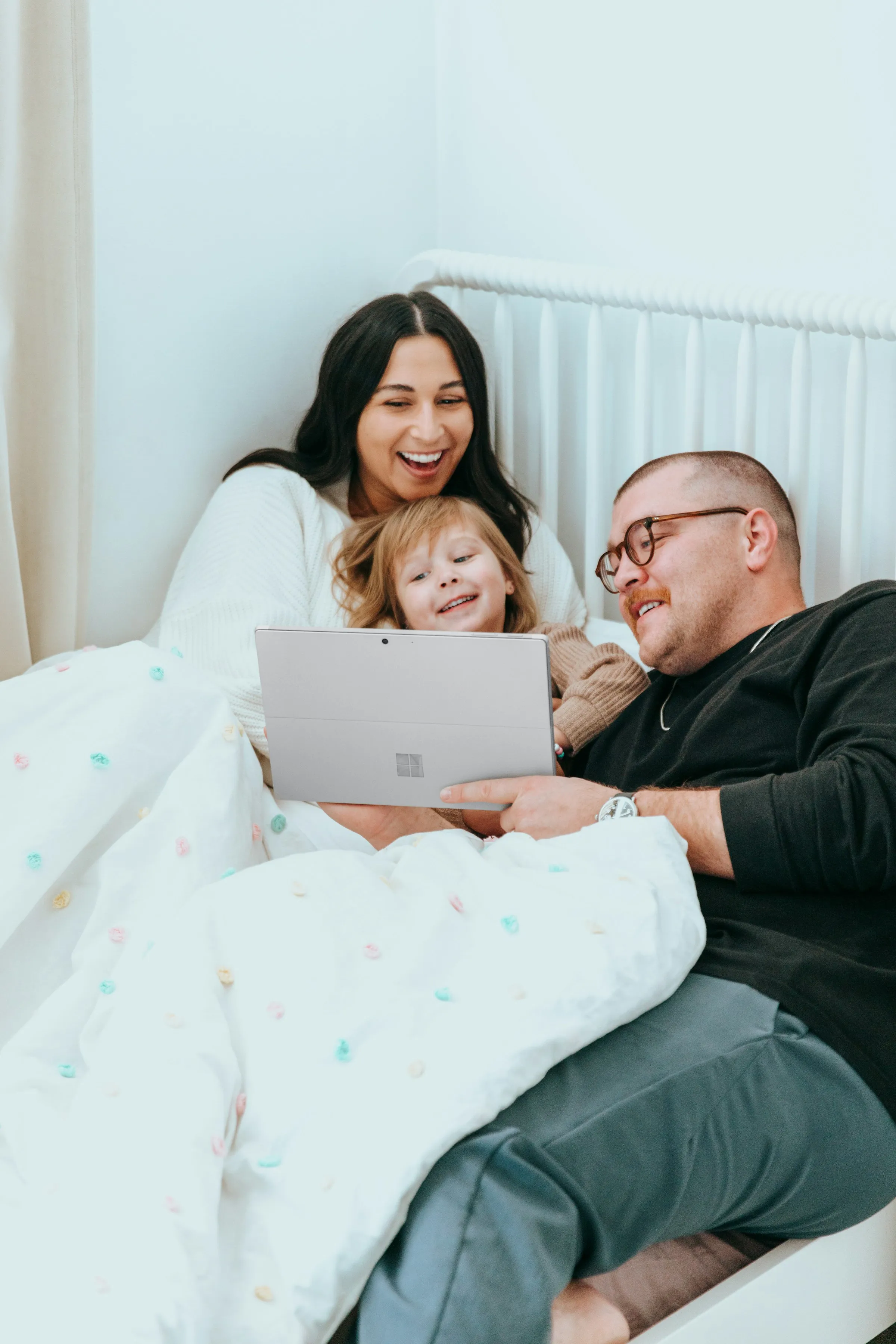 A family on a bed with a tablet